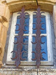 Sarrasines de fer forgé sur la fenêtre d'une maison de la place du château à Panat